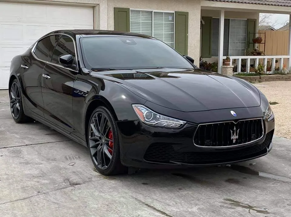Black Maserati Ghibli luxury sedan parked in residential driveway