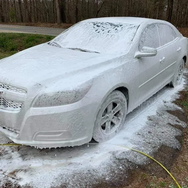 White sedan covered in ice and frost in a driveway during winter weather