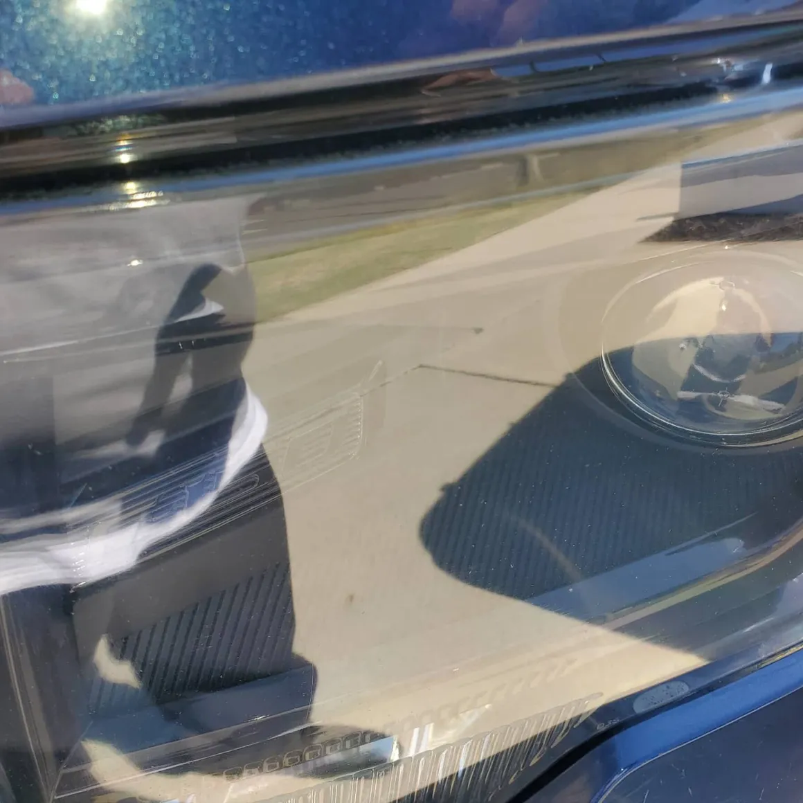 Close-up of blue car dashboard and windshield with sunlight reflections